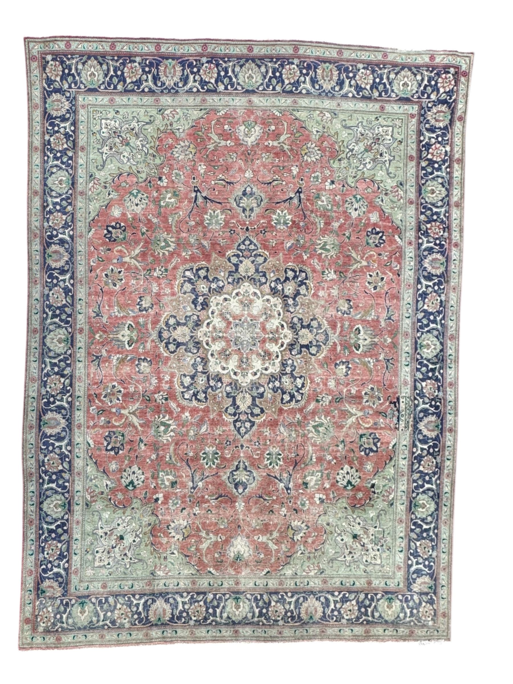 Persian rose ground rug, large central floral medallion surrounded by scrolling foliate and floral motifs, pale green spandrels, wide border in pale green and navy with intricate floral designs, framed by multiple guard stripes with repeating floral and geometric patterns