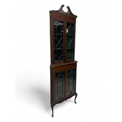 Edwardian mahogany corner display cabinet, scrolled swan neck pediment over astragal glaze...