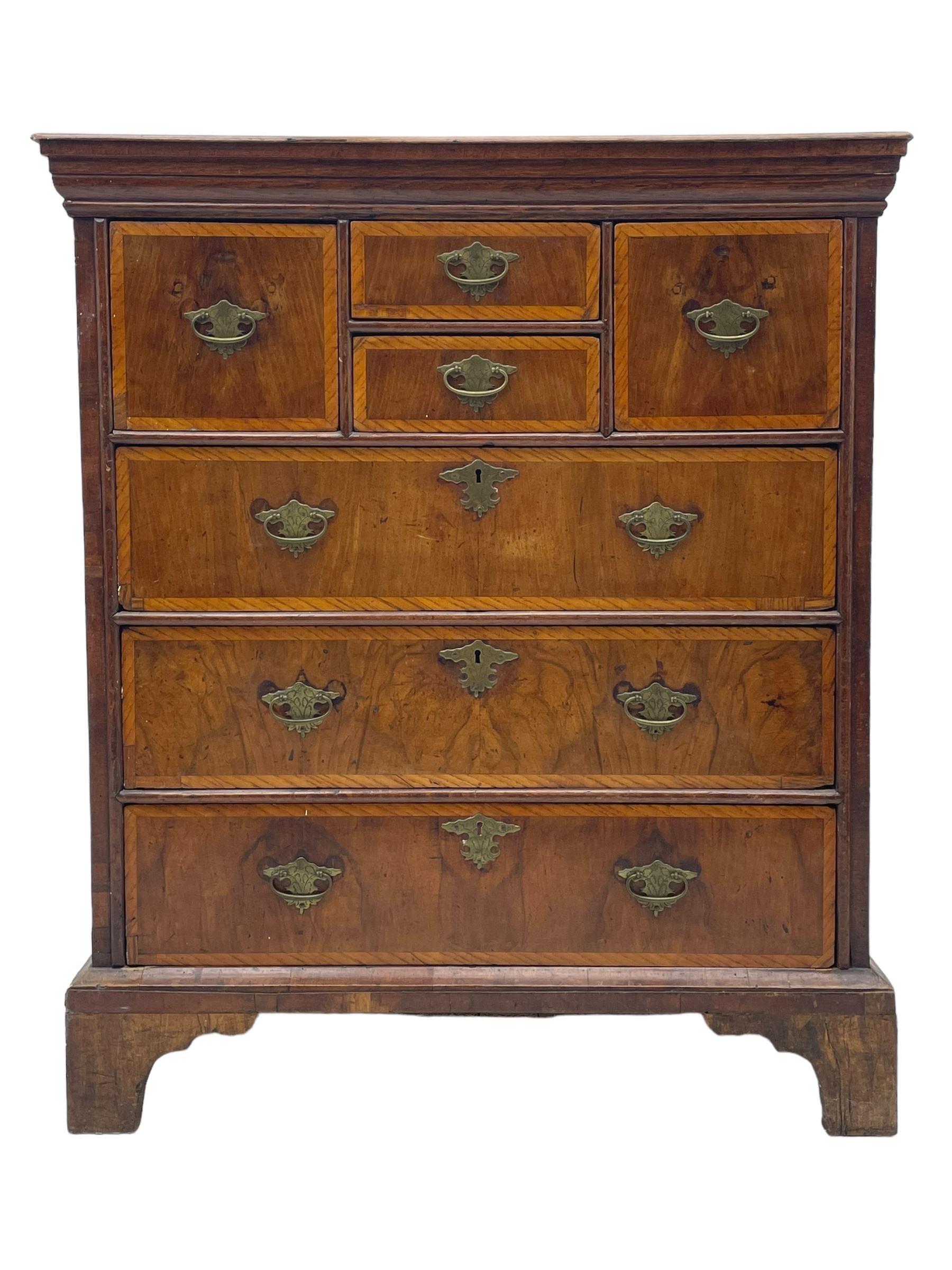 18th century oak and walnut chest, fitted with four small over three long drawers with figured walnut facias, brass handles and plates with engraved decoration, on bracket feet