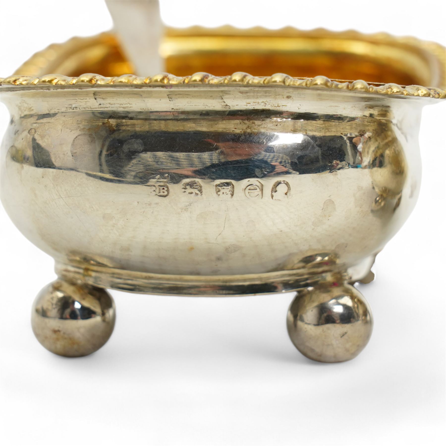 Pair of George III silver salts of elongated oval design with gilded interior and gadrooned border engraved with a monogram, raised on ball feet each 8.5cm x 6cm London 1820 Maker Rebecca Emes and Edward Barnard I together with a pair of later salt spoons