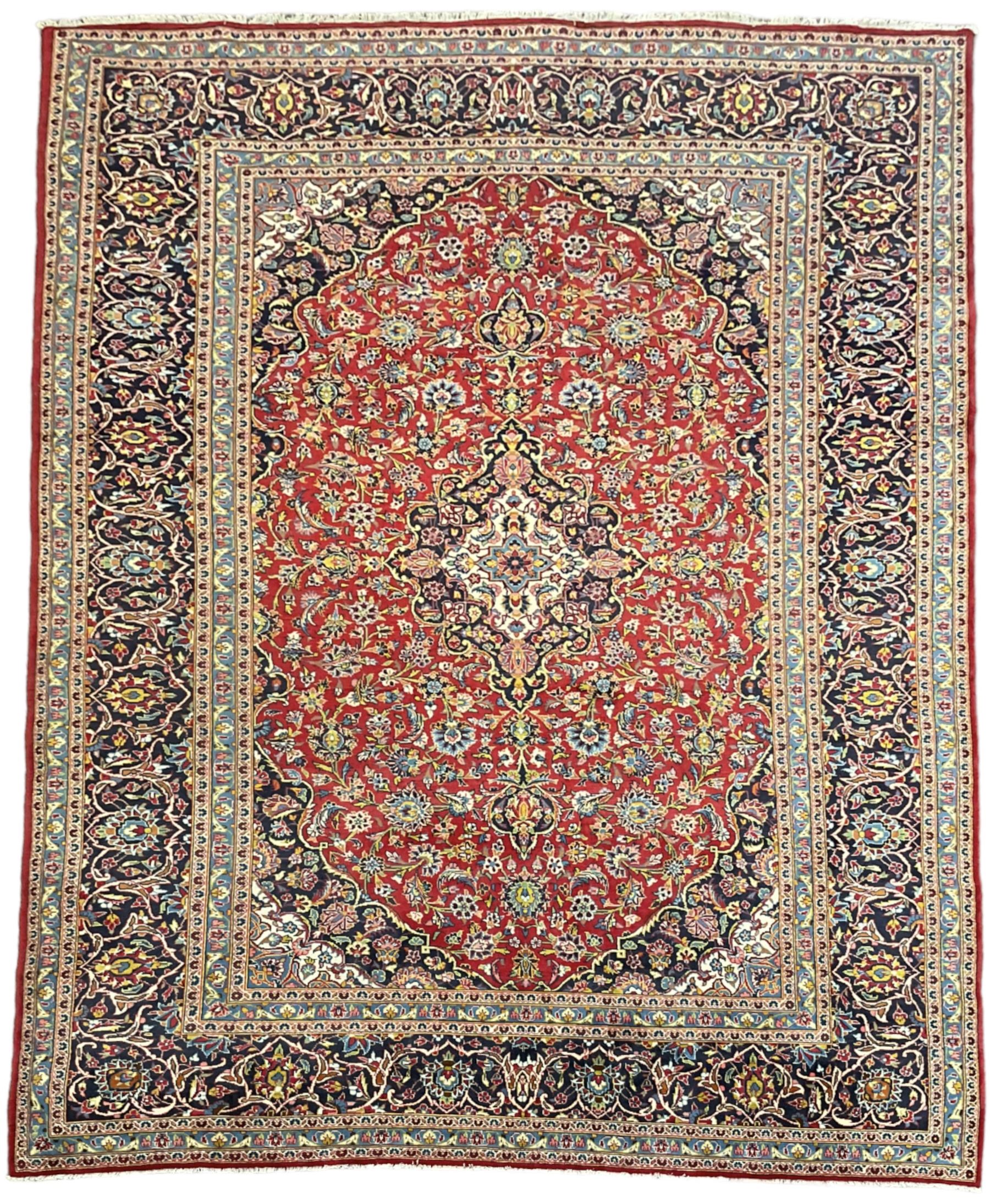 Persian Kashan crimson ground carpet, floral design central medallion surrounded by trailing leafy branches and stylised plant motifs, multi-band border with repeating floral design