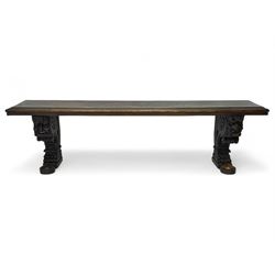 Victorian oak bench, moulded rectangular top, on mask and scroll carved corbel supports with paw feet, rectangular platforms with rounded terminals and applied roundel 