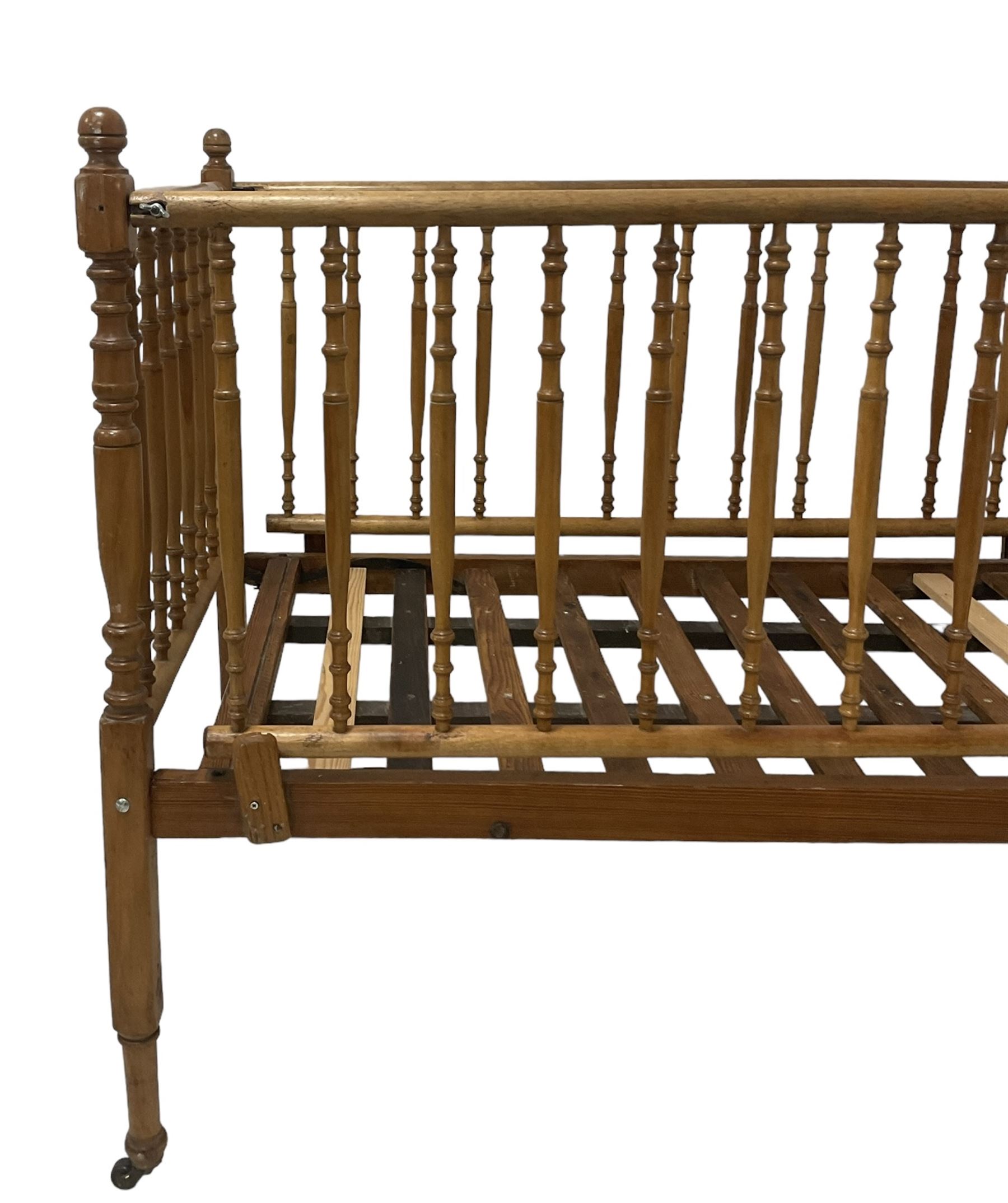 Victorian beech and pitch pine crib, turned spindle gallery supports, raised on square tapering supports with castors