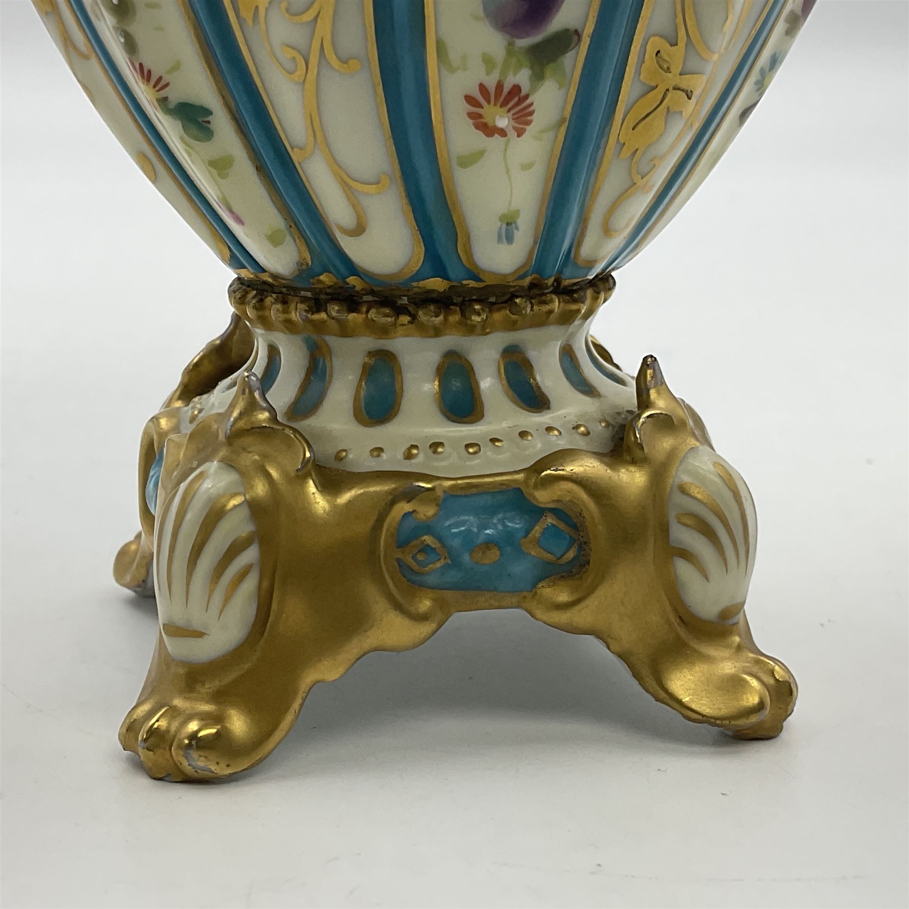 Pair of late 19th/early 20th century Sevres style vases and covers, of baluster form with gilt scroll handles and domed covers, the wrythen fluted bodies decorated with alternating bands of painted fruit and flowers and gilt vines, upon a white and celeste blue ground, with printed and impressed marks beneath, H22.5cm 