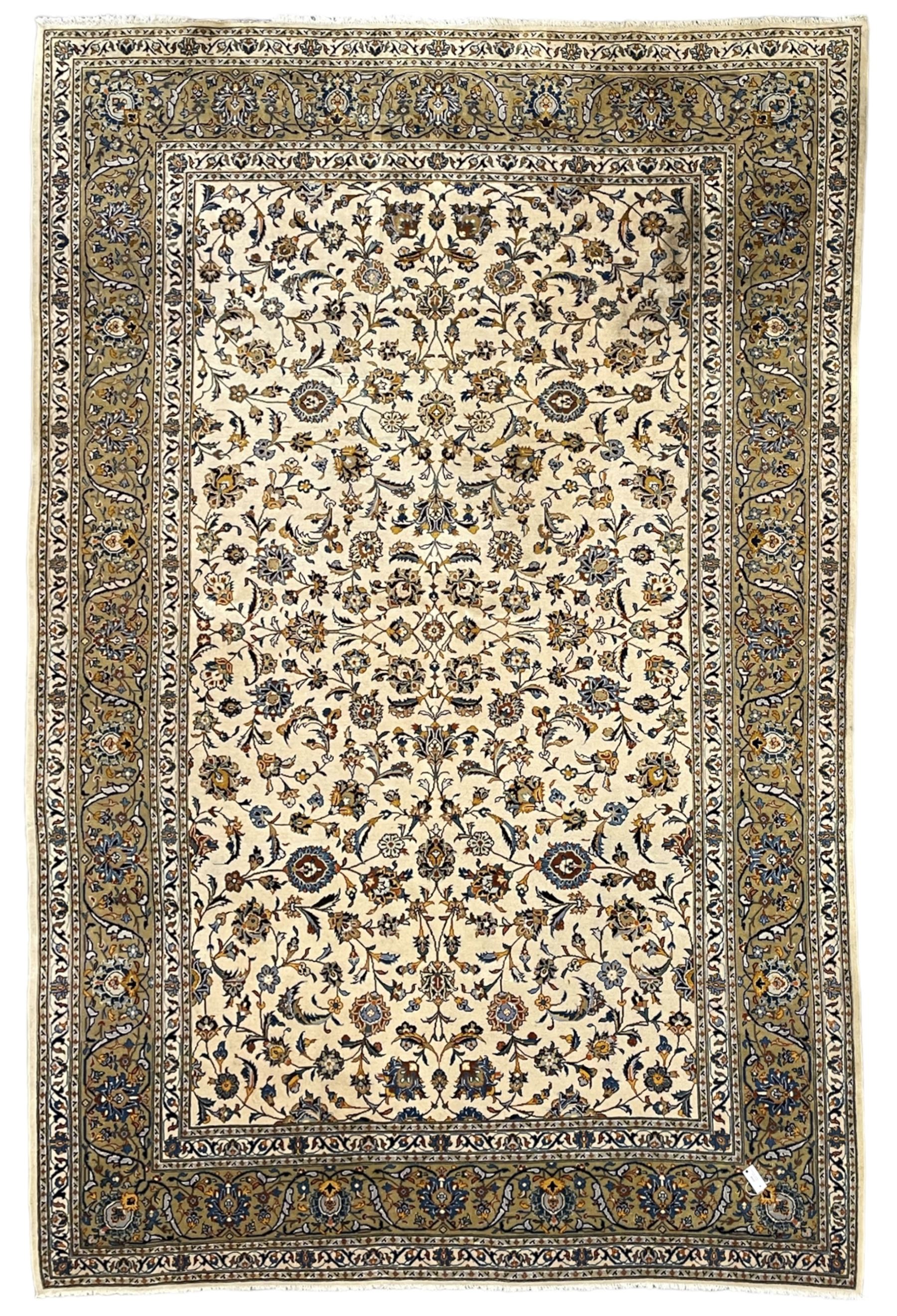 Persian Kashan ivory ground carpet, the field decorated with trailing foliate branches and stylised flower head motifs, guarded border with repeating design decorated with scrolling leafy branch and plant motifs 