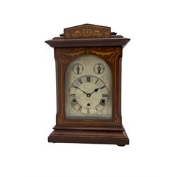  An Edwardian c1905 Westminster chiming mantle clock in a mahogany Sheraton style case with inlay and stringing, with a silvered one-piece dial with etched decoration, Roman numerals and minute track, with subsidiary strike/ silent dial and pendulum regulation dial, eight-day German three train movement striking the quarters on 5 gong rods. With pendulum and key.


.


