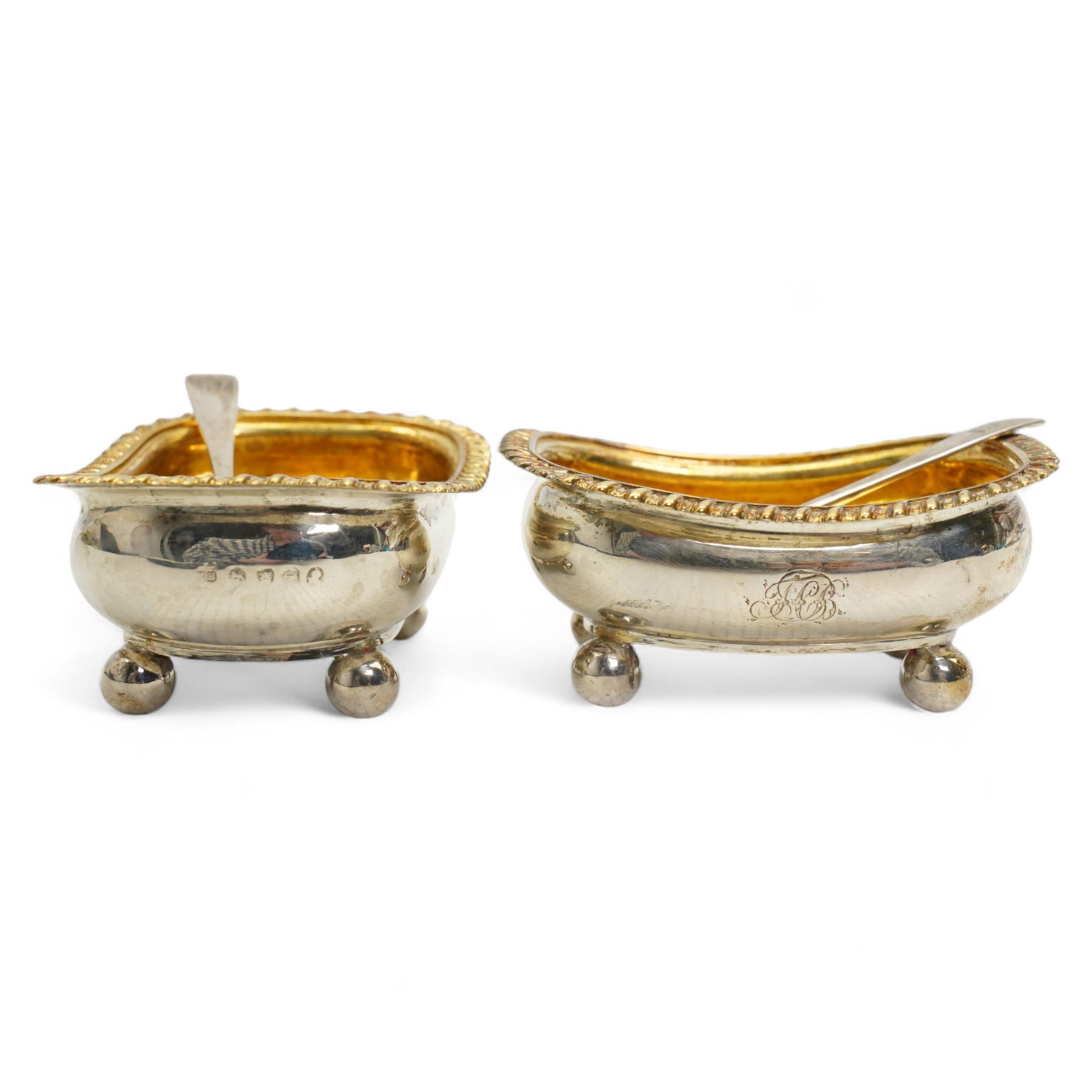 Pair of George III silver salts of elongated oval design with gilded interior and gadrooned border engraved with a monogram, raised on ball feet each 8.5cm x 6cm London 1820 Maker Rebecca Emes and Edward Barnard I together with a pair of later salt spoons