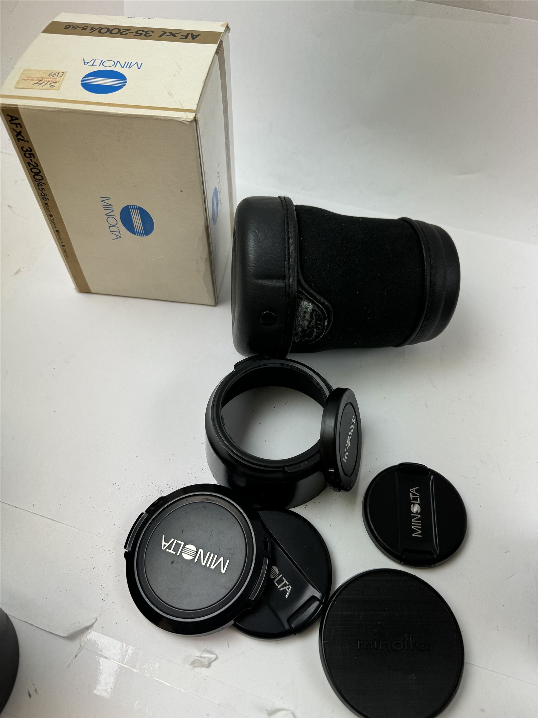 Six Minolta camera lenses, to include AF xi 35-200/4.5-5.6 serial no. 21148974, boxed, AF Zoom Xi 100-300mm 1:4.5(32)-5.6 lens serial no. 32205497, AF Zoom 28-135mm 1:4(22)-4.5 lens serial no. 1001096, MC Tele Rokkor-QF 1:3.5 f=200mm lens serial no. 5512665, MD Zoom 70-210mm 1:4 lens serial no. 1056195 and an MC Tele Rokkor-PF 1:28 f=135mm lens serial no. 1173532