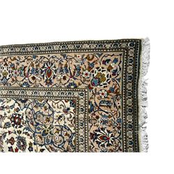 Persian Kashan ivory ground rug, central floral medallion surrounded by interlacing leafy branches and stylised plant motifs, scrolling spandrels, the border decorated with trailing branch and repeating palmettes, within floral pattern guard stripes 