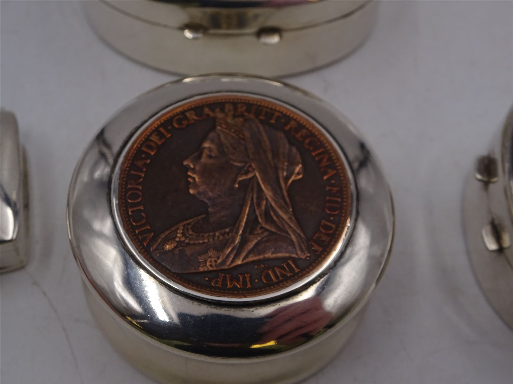 Four silver boxes, comprising oval example embossed with horse and rider, a rectangular example set with heart shaped amethyst, an oval example with set with carved abalone shell portrait, and a circular example set with Victorian penny, all hallmarked 