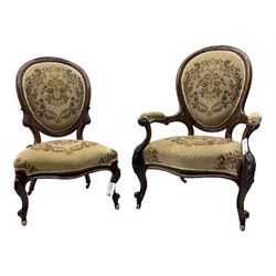 Pair of Victorian walnut lady's and gentleman's drawing room chairs, arched cresting rail carved with cartouche and extending foliage, upholstered in floral pattern fabric, on foliate carved cabriole feet