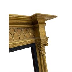 Regency design giltwood overmantel mirror, projecting cornice over pointed arcade frieze and foliate moulded upper edge, plain mirror plate within reed moulded ebonised slip, flanked by cluster columns with acanthus and scroll decorated Composite order capitals 