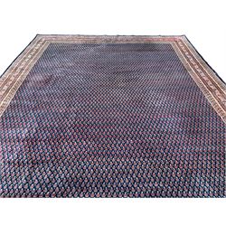 Large North-West Persian Arrak indigo ground carpet, the field decorated all-over with small Boteh motifs, multiple band border decorated with repeating geometric designs