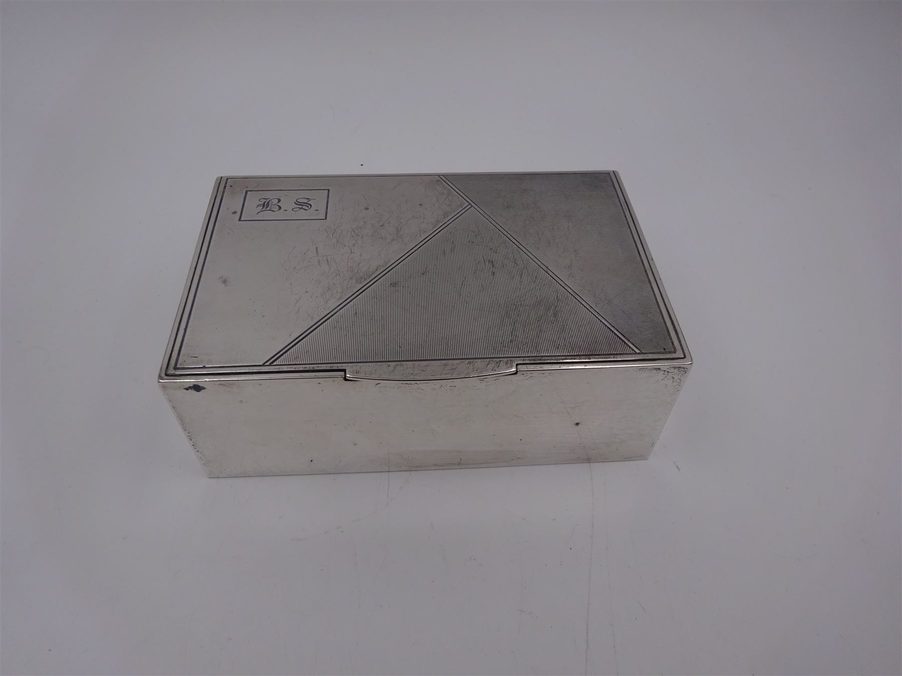 1930s silver mounted cigarette box, of rectangular form, with engine turned decoration and engraved cartouche to hinged lid, opening to reveal a softwood interior, hallmarked London 1930, maker's mark worn and indistinct