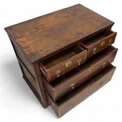 Early 18th century oak chest, rectangular top over two short and two long drawers with yew wood bands, shaped handles and escutcheons with drop handles, on stile supports 