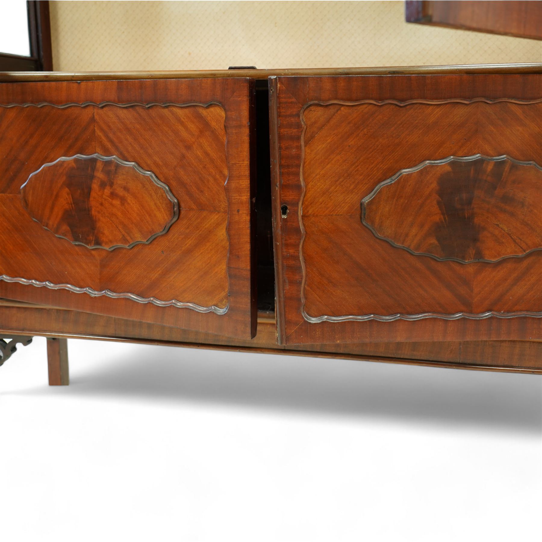 Early 20th century mahogany display cabinet, enclosed by astragal glazed doors over two scalloped panelled cupboard doors, on square supports with pierced scrolling brackets