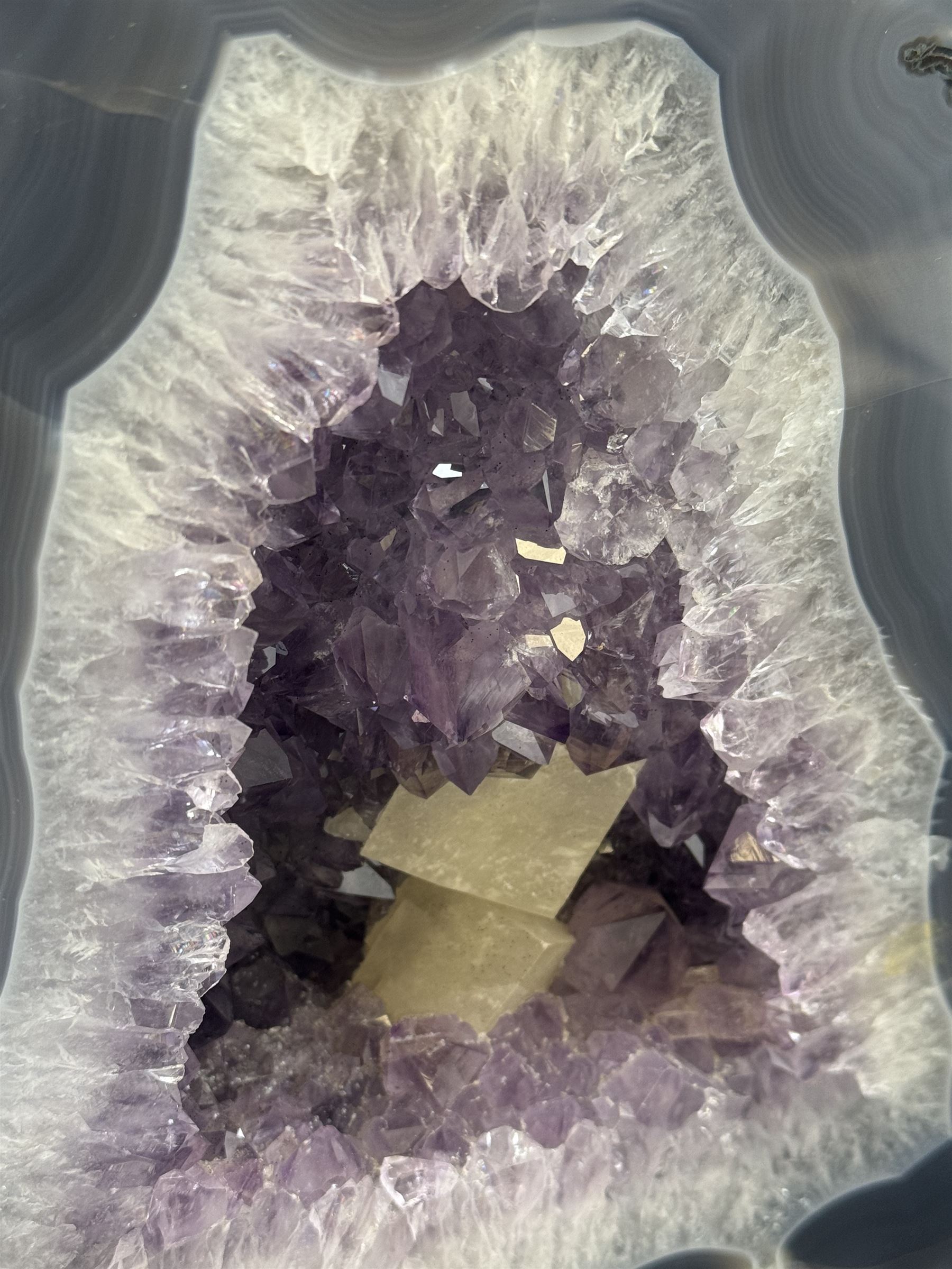 Amethyst crystal ‘cathedral’ geode, free standing with flat base and prepared outer surface, with well-defined crystals of various sizes within the cavern, H25cm, W25cm