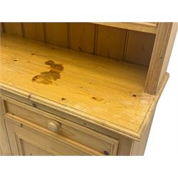 Traditional design waxed pine dresser, upper section with moulded cornice over scalloped frieze, fitted with two open shelves and four drawers, lower section with three drawers over three panelled cupboards, on plinth base