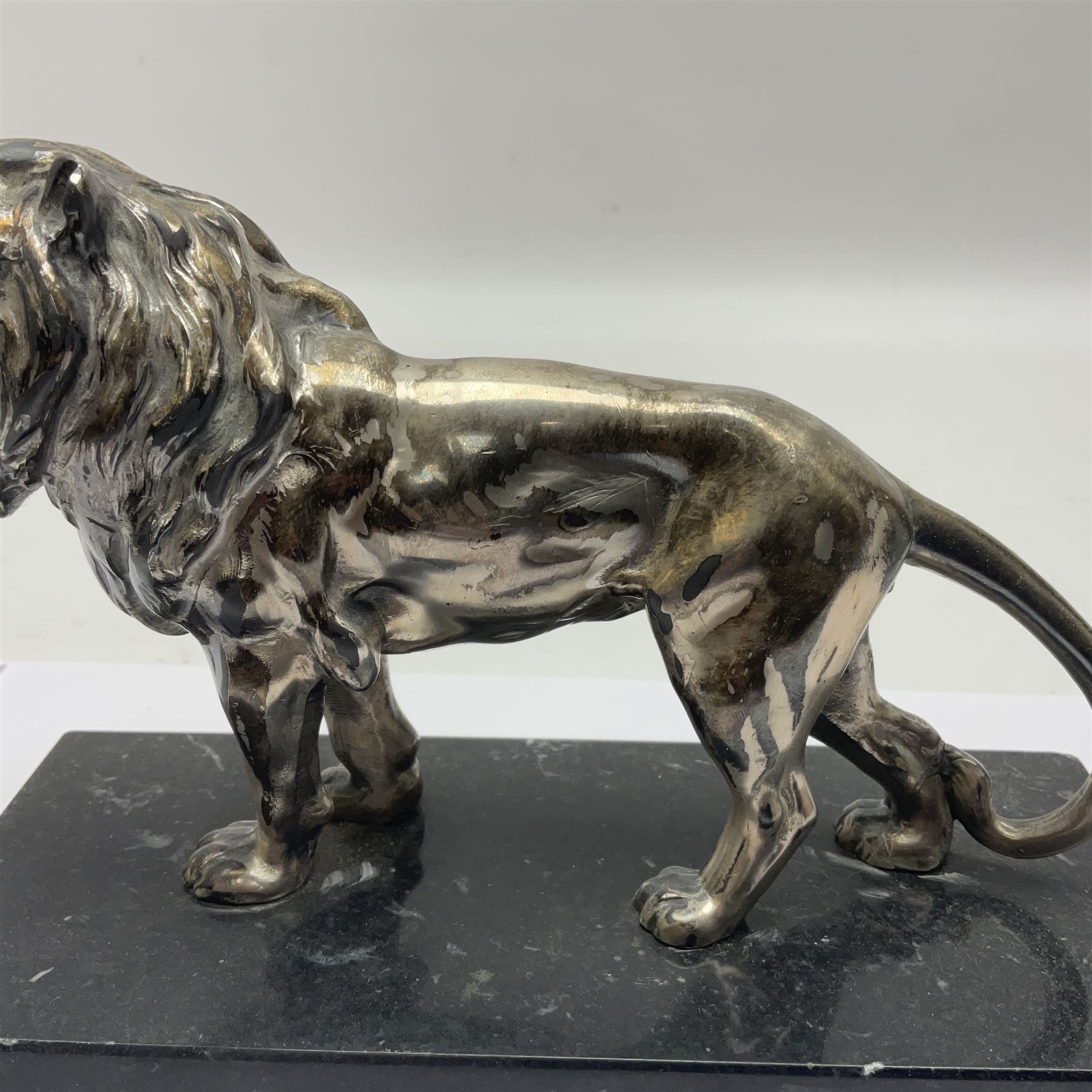 Silvered metal lion, upon a rectangular base, H12cm