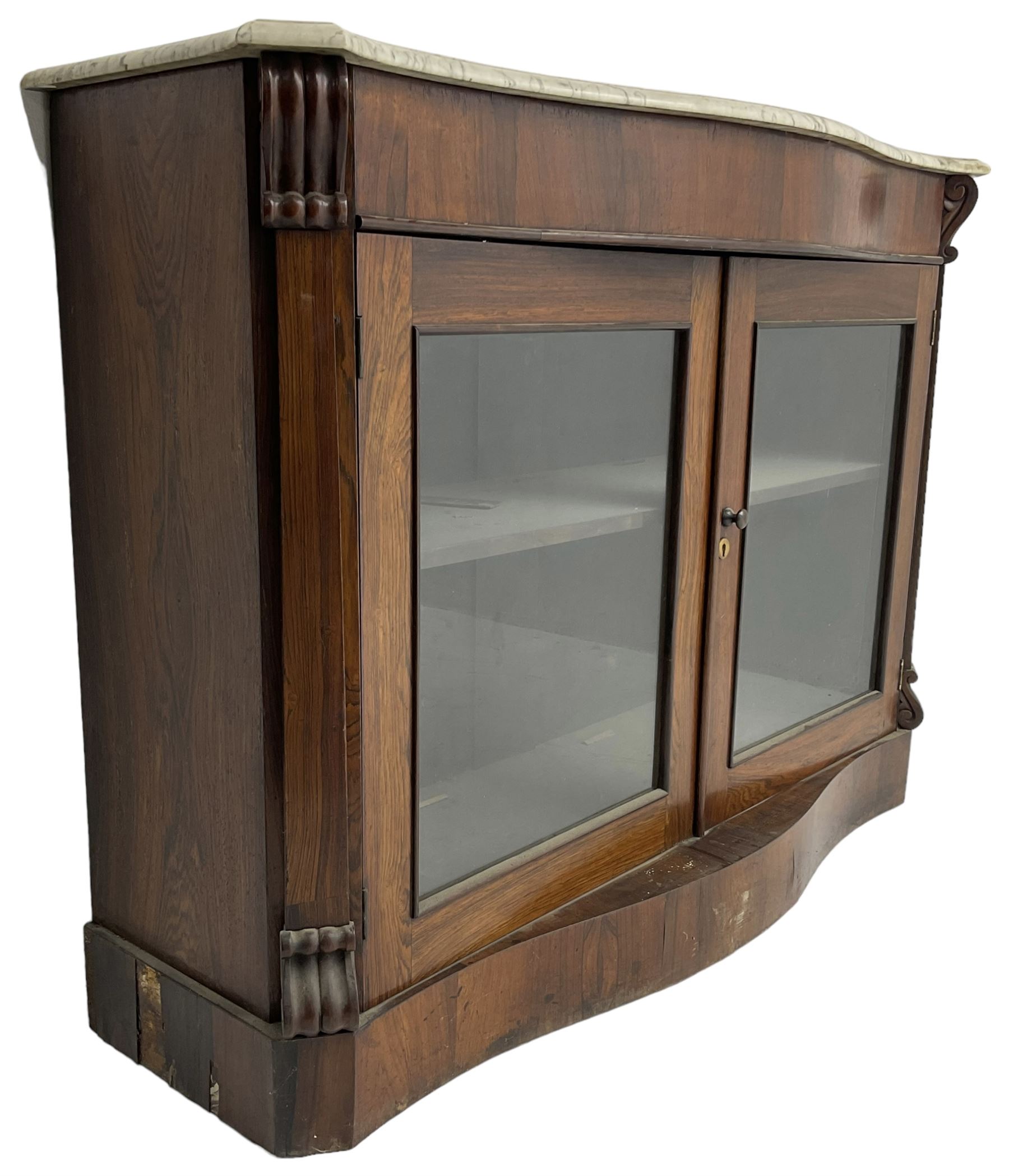 Victorian rosewood side cabinet, shaped and moulded white marble top over plain frieze, single shelf enclosed by two glazed doors, flanked by square pilasters with S-scroll carved brackets, on plinth base