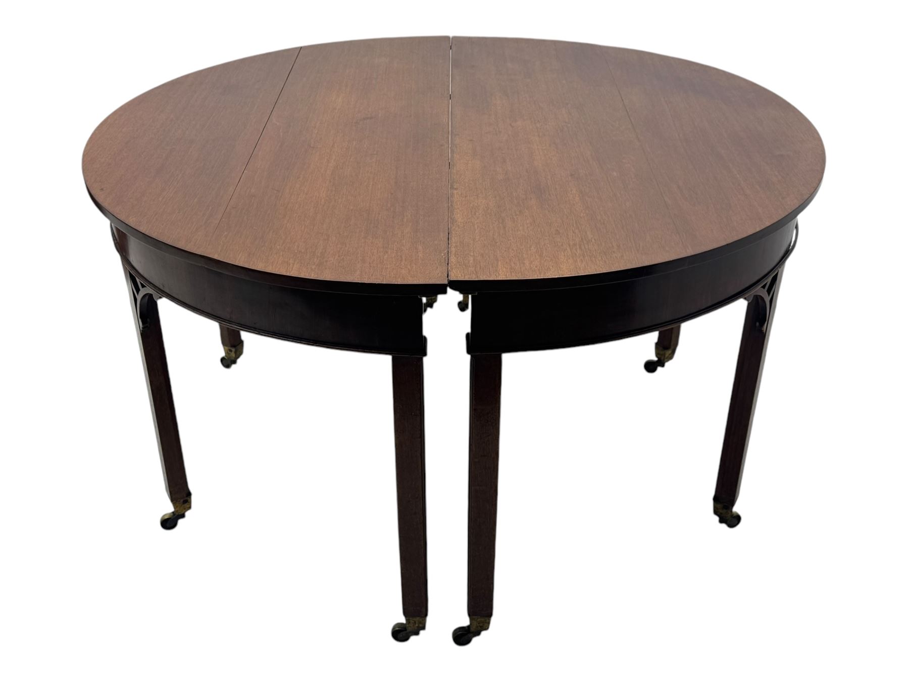 Early 19th century mahogany demi-lune extending dining table, two D-ends with central leaf insert, raised on eight square supports with arched spandrels terminating in brass castors