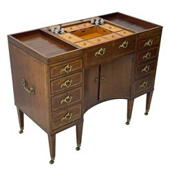 Late 19th century mahogany and satinwood dressing chest, the raised middle section hinges to reveal an interior fitted with lidded compartments, removable tray, single drawer and glass scent bottles, lift-up bevelled mirror with adjustable hinged mechanism, fitted with a further eight cock-beaded graduating drawers and curved kneehole with double cupboard, square tapering supports on brass cups and castors, inlaid throughout with checkered stringing, ornate Rococo cast gilt metal handles