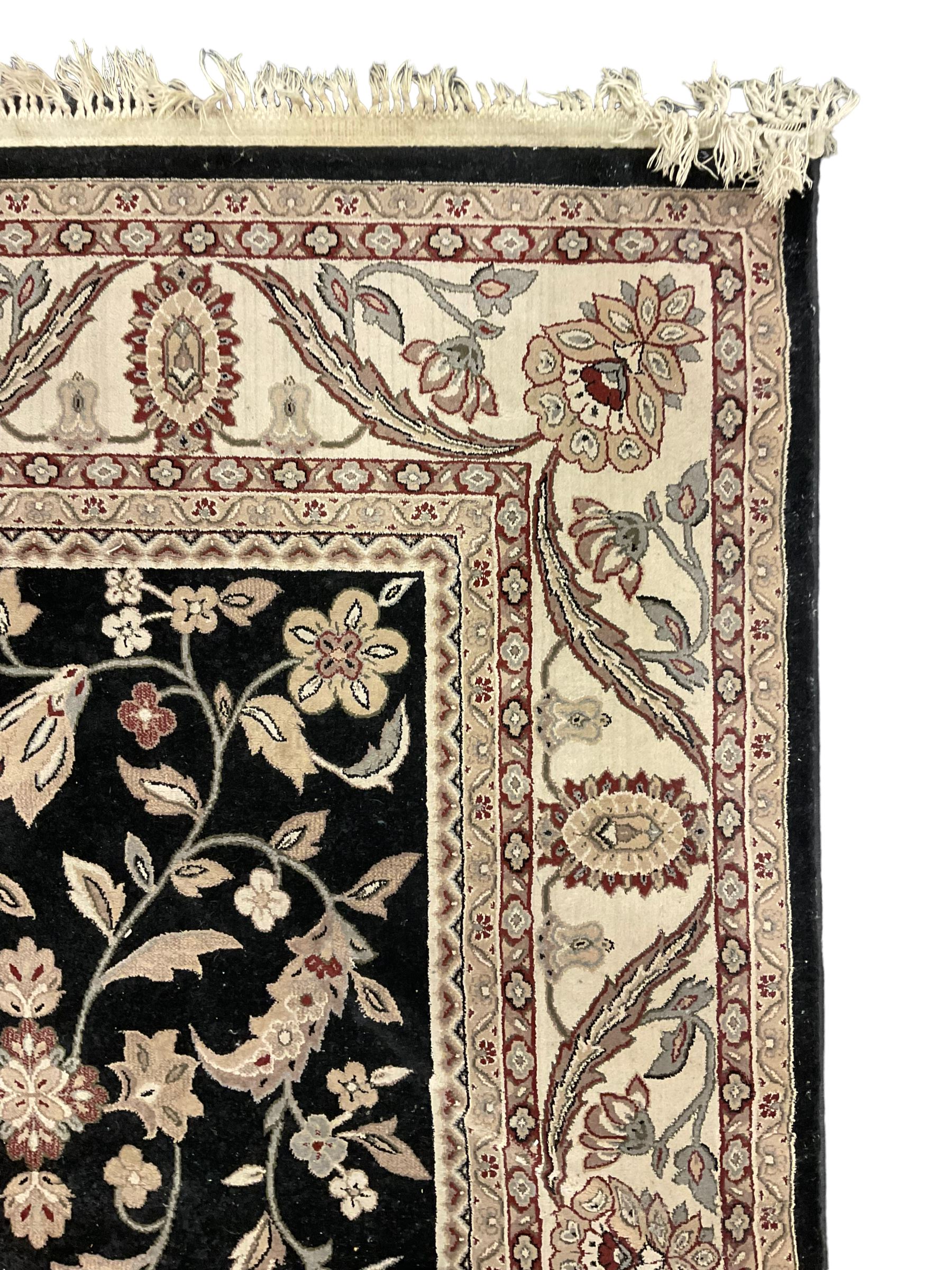 Persian design dark indigo ground rug, the field decorated with trailing branches and foliate motifs, repeating scrolling border with stylised plant motifs