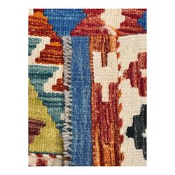 Kilim runner rug, central field decorated with four stacked geometric medallions in a multicoloured zigzag design, bordered by a series of small geometric motifs, fringed edges at both ends