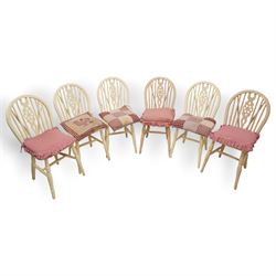 20th century pine kitchen dining table, stained top over cream painted base (W133cm D81cm H77cm); and six painted wheel-back chairs (H89cm)