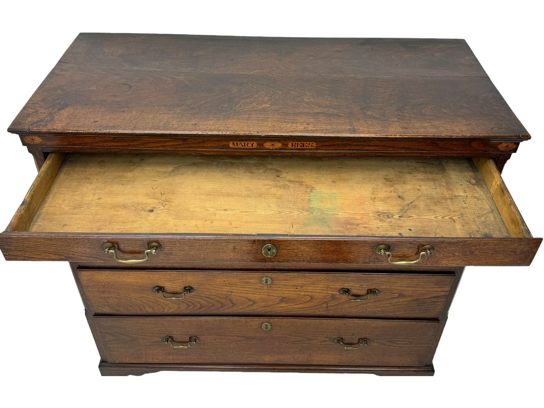 George III oak chest, rectangular top over frieze with inlaid with inscription panels 'Mary Rees' and fan motifs, frieze drawer over two short and three long graduating drawers, fitted with brass swan-neck handles and oval escutcheons, on bracket feet