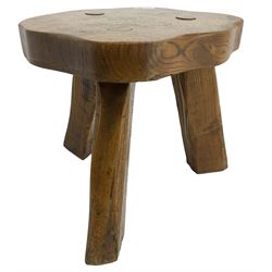 Small rustic elm three-legged stool, with metal plaque to the underneath inscribed 'Wandewood' 