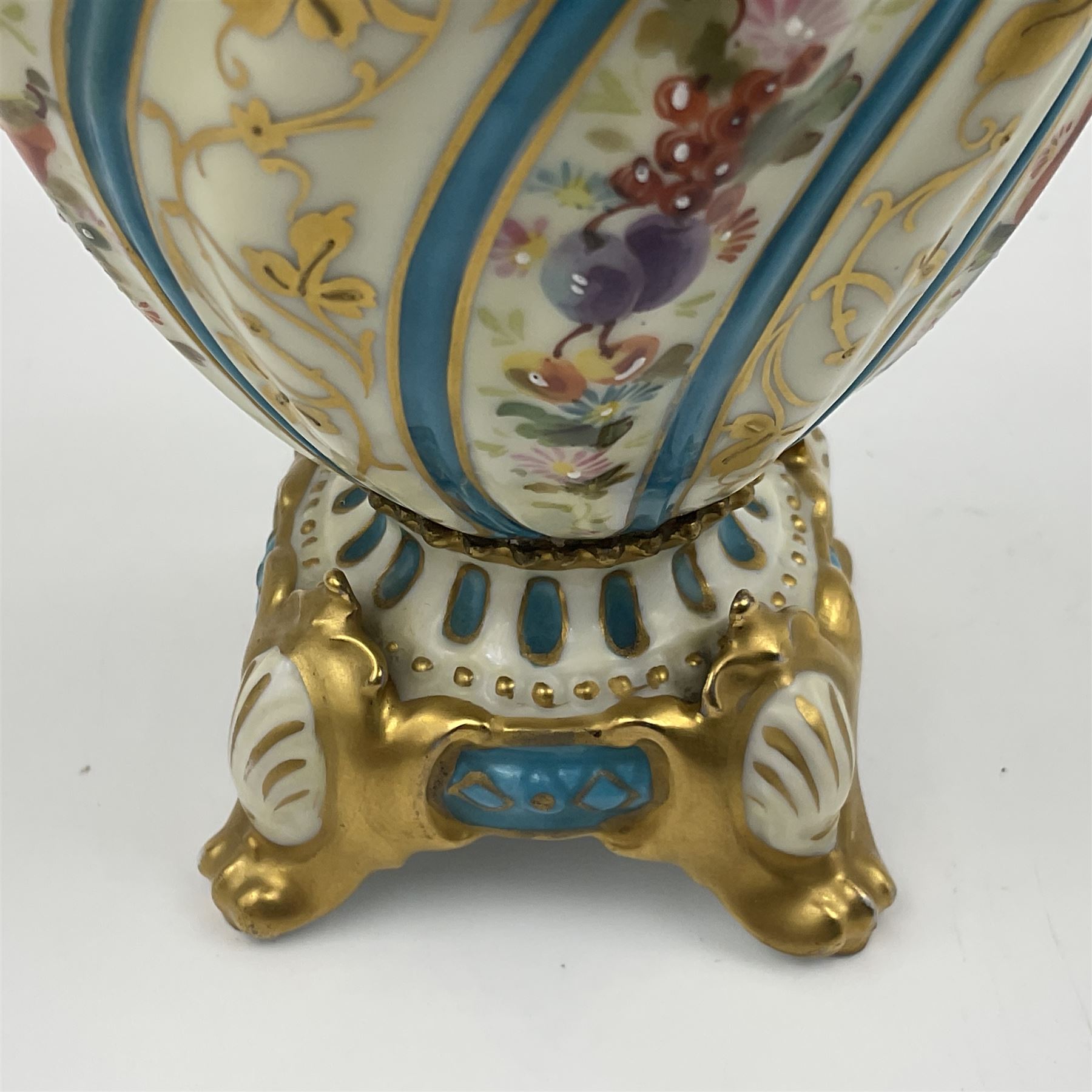 Pair of late 19th/early 20th century Sevres style vases and covers, of baluster form with gilt scroll handles and domed covers, the wrythen fluted bodies decorated with alternating bands of painted fruit and flowers and gilt vines, upon a white and celeste blue ground, with printed and impressed marks beneath, H22.5cm 