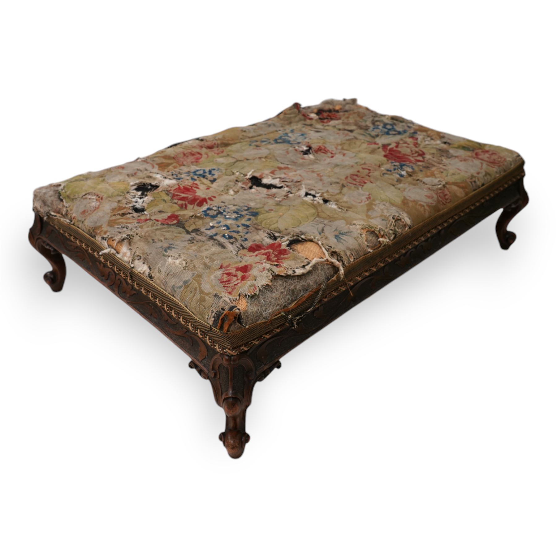 Victorian walnut low stool, rectangular form with needlework cover, the frieze rails carved with trailing foliate decoration, on cabriole feet with scroll carved terminals 