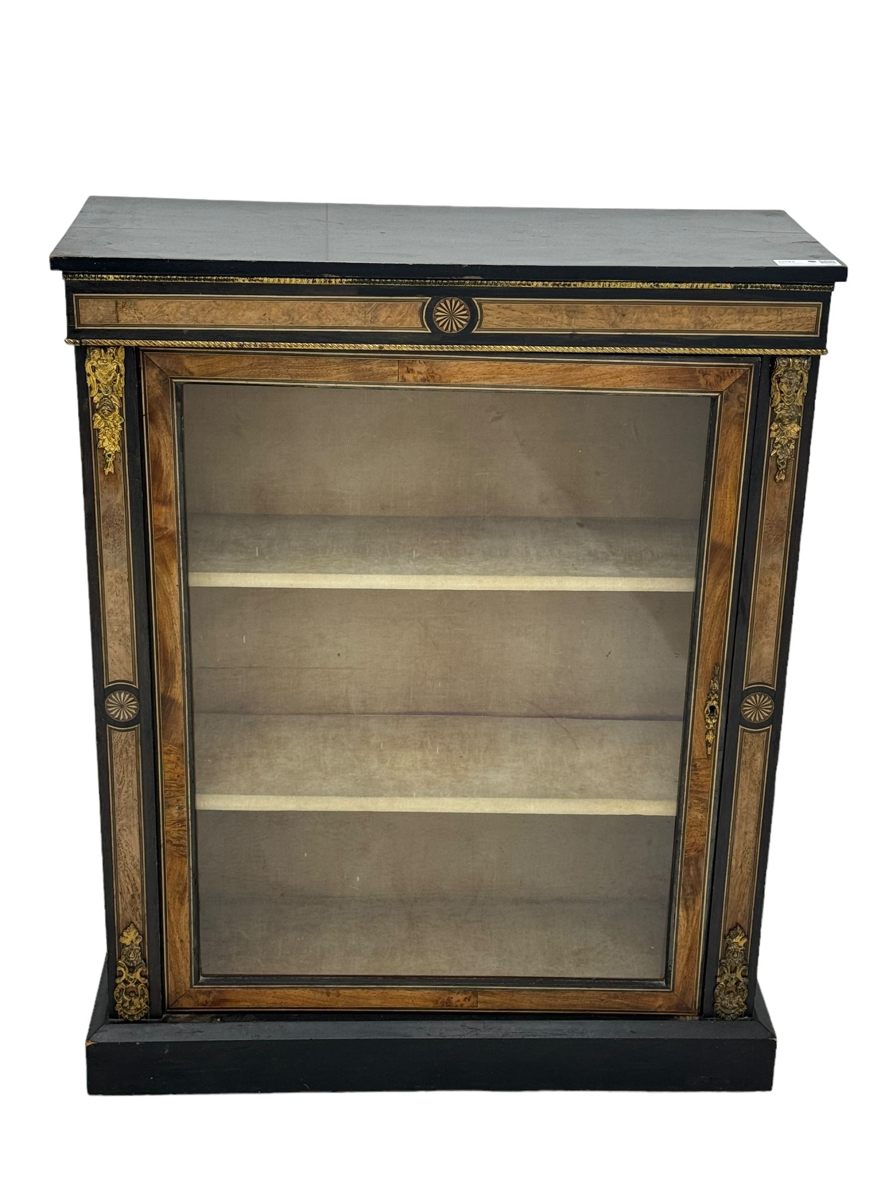 Victorian ebonised and walnut pier cabinet, rectangular top over figured frieze with central star motifs, enclosed by single glazed door, decorated with cast gilt metal mounts and beading, on chamfered plinth base 