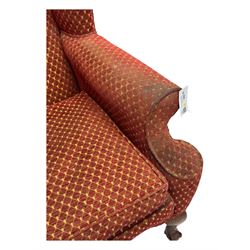 Early 20th century hardwood-framed wingback armchair, upholstered in red dotted fabric, on cabriole feet