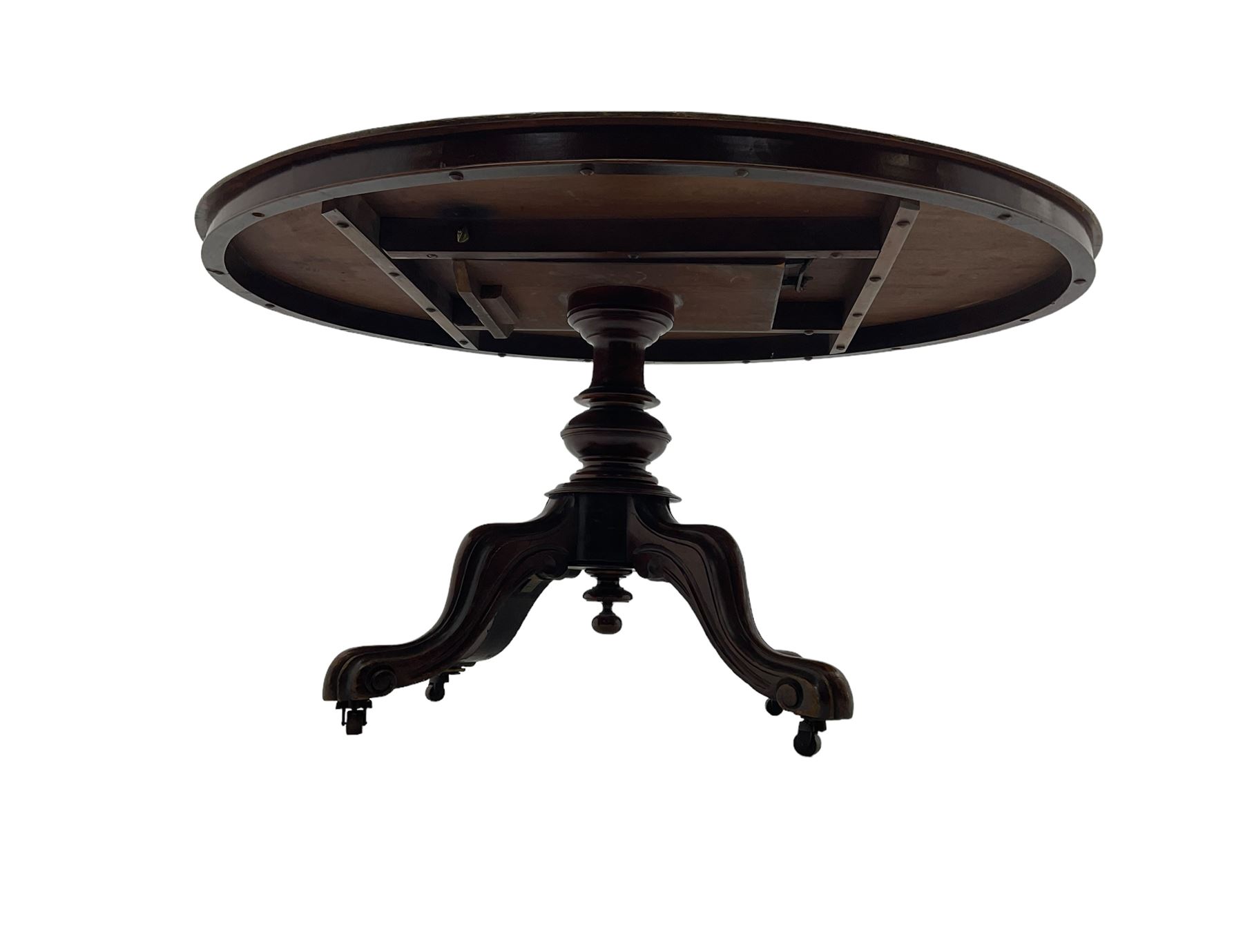 Victorian mahogany loo or dining table, oval moulded tilt-top on turned pedestal, four out splayed supports with scrolled carved terminals (137cm x 101cm, H75cm); together with set of four Victorian dining chairs upholstered in pale buttoned fabric, on turned front supports with brass and ceramic castors  