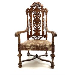 20th century Carolean style carved oak armchair, the back carved with scrolls and foliage, lobe carved supports joined by curved x-frame stretchers