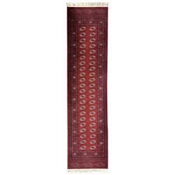 Persian Bokhara crimson ground runner rug, the field with a series of repeating ivory octagonal medallions, main border with repeating flower head pattern and diamonds within multiple guard stripes