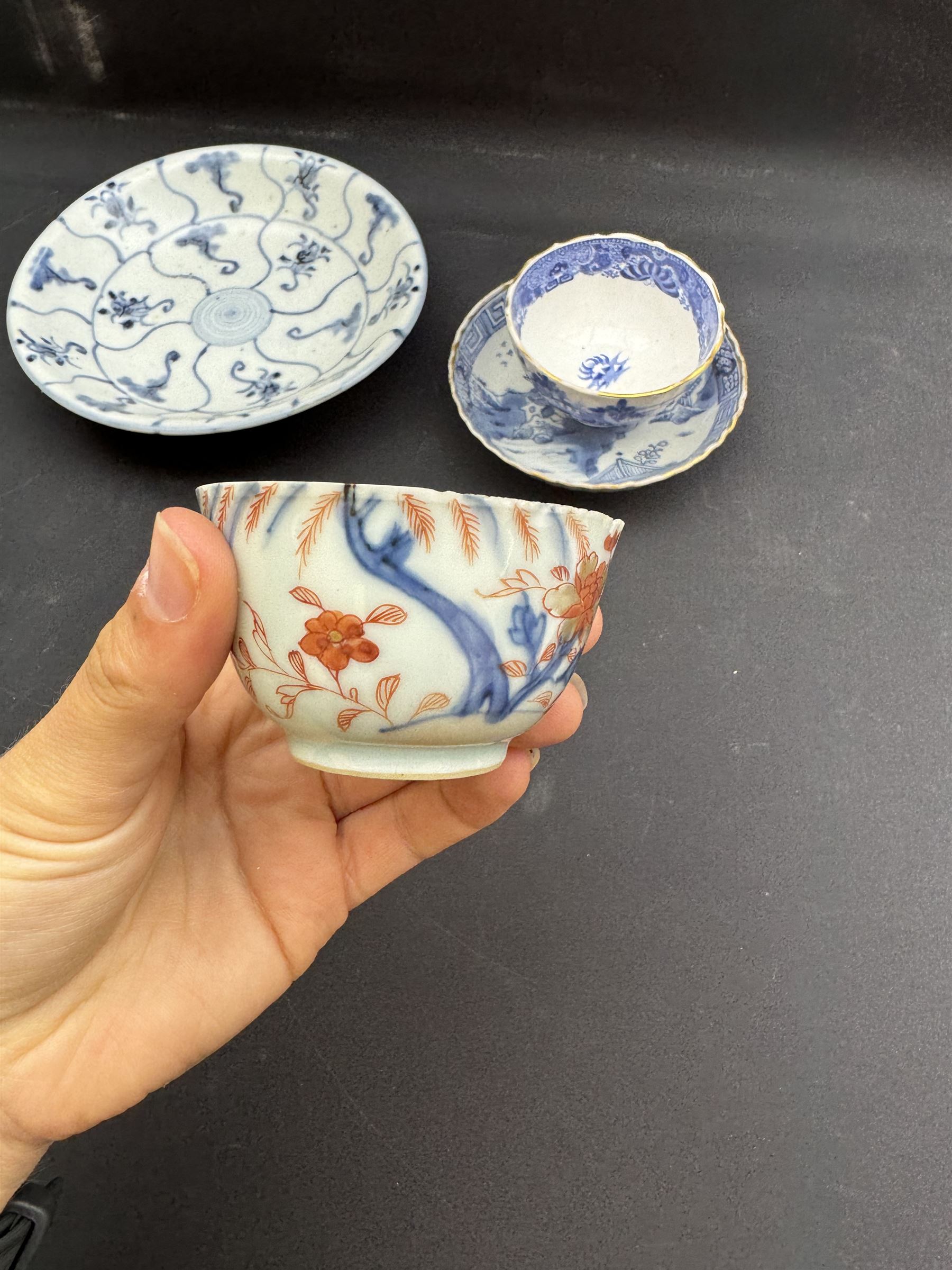 Early 19th century Chinese Tek Sing bowl, decorated with stylised blossoms, with 'Nagel Auctions' label to base, H6.5cm D15.5cm, together with a  Tek Sing similar saucer, D18cm, a Chinese tea bowl decorated in blue and red blossoming flowers, a Chinese blue and white saucer, and an English blue and white Willow pattern tea bowl, (5)