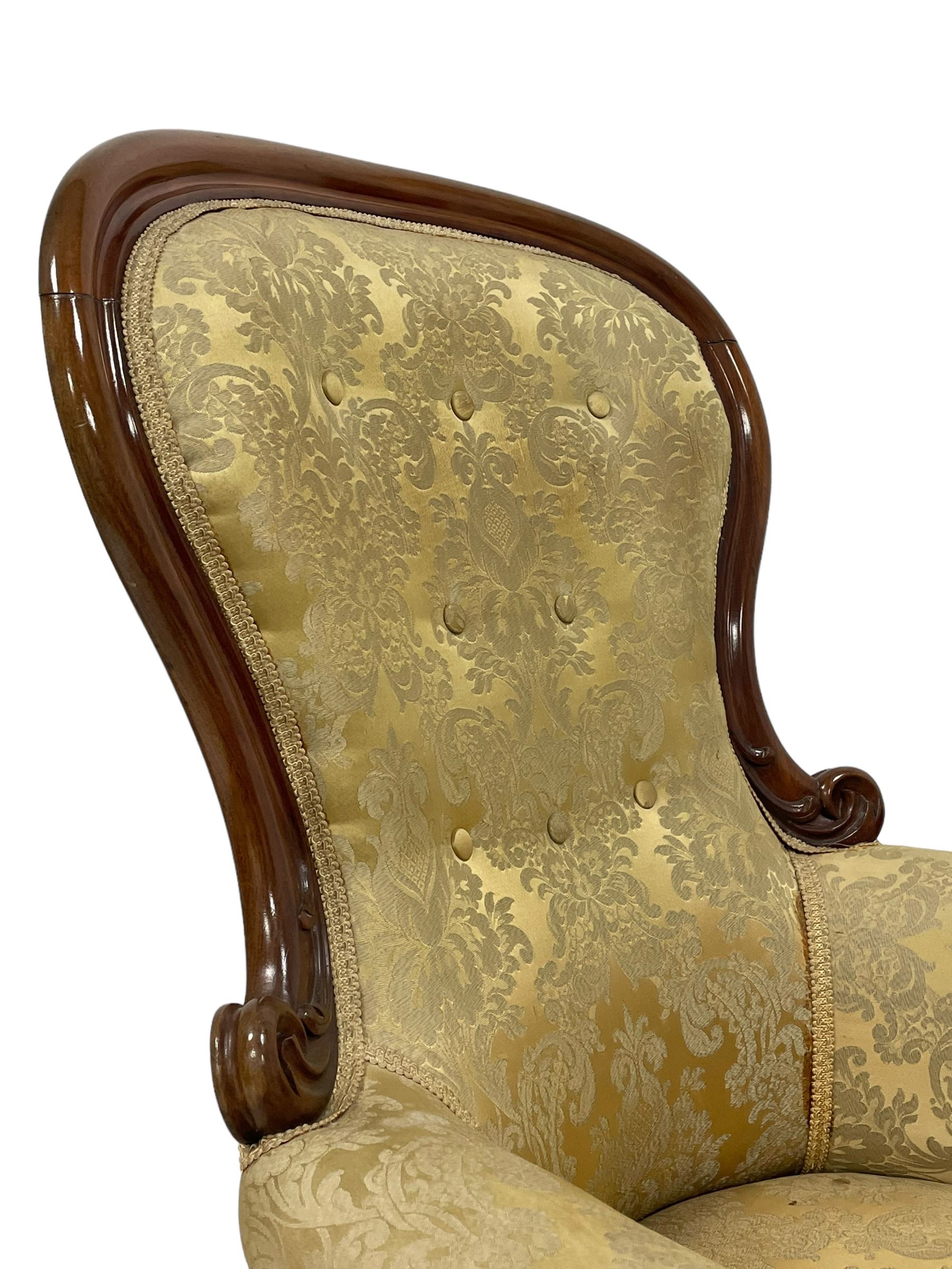 Victorian mahogany framed armchair, shaped and moulded frame carved with curled foliage, upholstered in pale gold floral pattern silk damask fabric, scrolled arm terminals on shaped moulded supports terminating to scroll carved feet