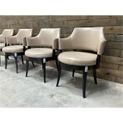 Four ebonised framed tub shaped armchairs, upholstered in beige fabric