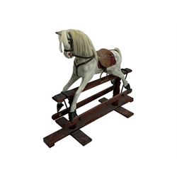 Mid 20th century rocking horse, dappled grey painted horse with applied mane and tail, red leather saddle and bridle accented with brass studs, supported by a stained wooden frame with turned supports and iron brackets, mounted on rockers