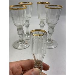 Set of four 19th century Baccarat liqueur/sherry glasses, circa 1820, with panelled bucket bowls and gilt rims, engraved CEG, to faceted knopped stems, together with another smaller example, H14cm and H12cm (5)