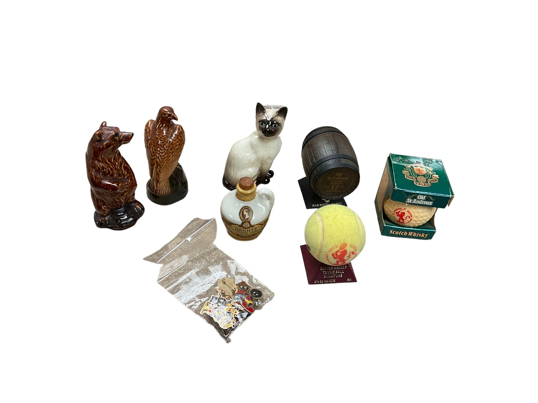 Six whisky miniatures in novelty decanters, together with Beswick cat, and nine Robertsons Golly badges