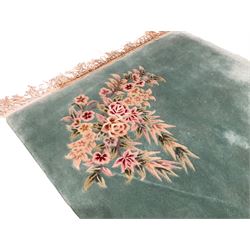 Chinese pale turquoise ground washed woolen rug, the plain field decorated with two large floral bouquet motifs with extending blossom and leafage