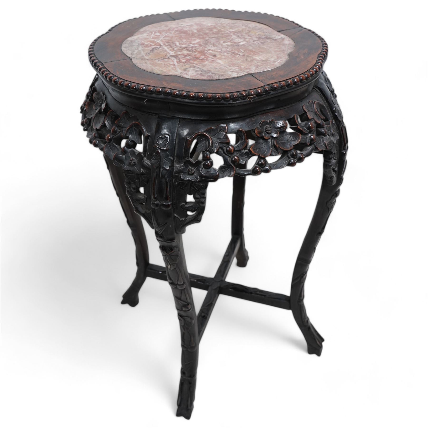 Early 20th century Chinese hardwood and marble top jardiniere or urn stand, shaped circular top with central marble inset and bead edge, over pierced and carved foliate rails with blossom design, the cabriole supports carved with trailing vines and leafage, united by X-stretcher on shaped claw feet