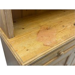 Traditional design waxed pine dresser, upper section with moulded cornice over scalloped frieze, fitted with two open shelves and four drawers, lower section with three drawers over three panelled cupboards, on plinth base