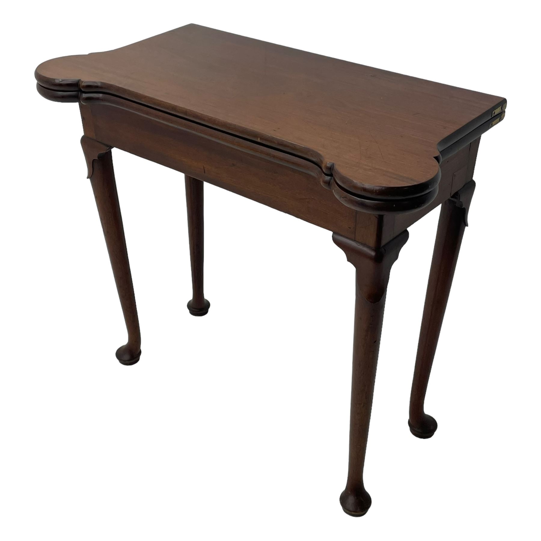 George III mahogany games table, the rectangular fold-over top with extending stepped rounded corners, opening to reveal baize lined interior with sunken counter wells, concertina action base, on lappet cabriole supports