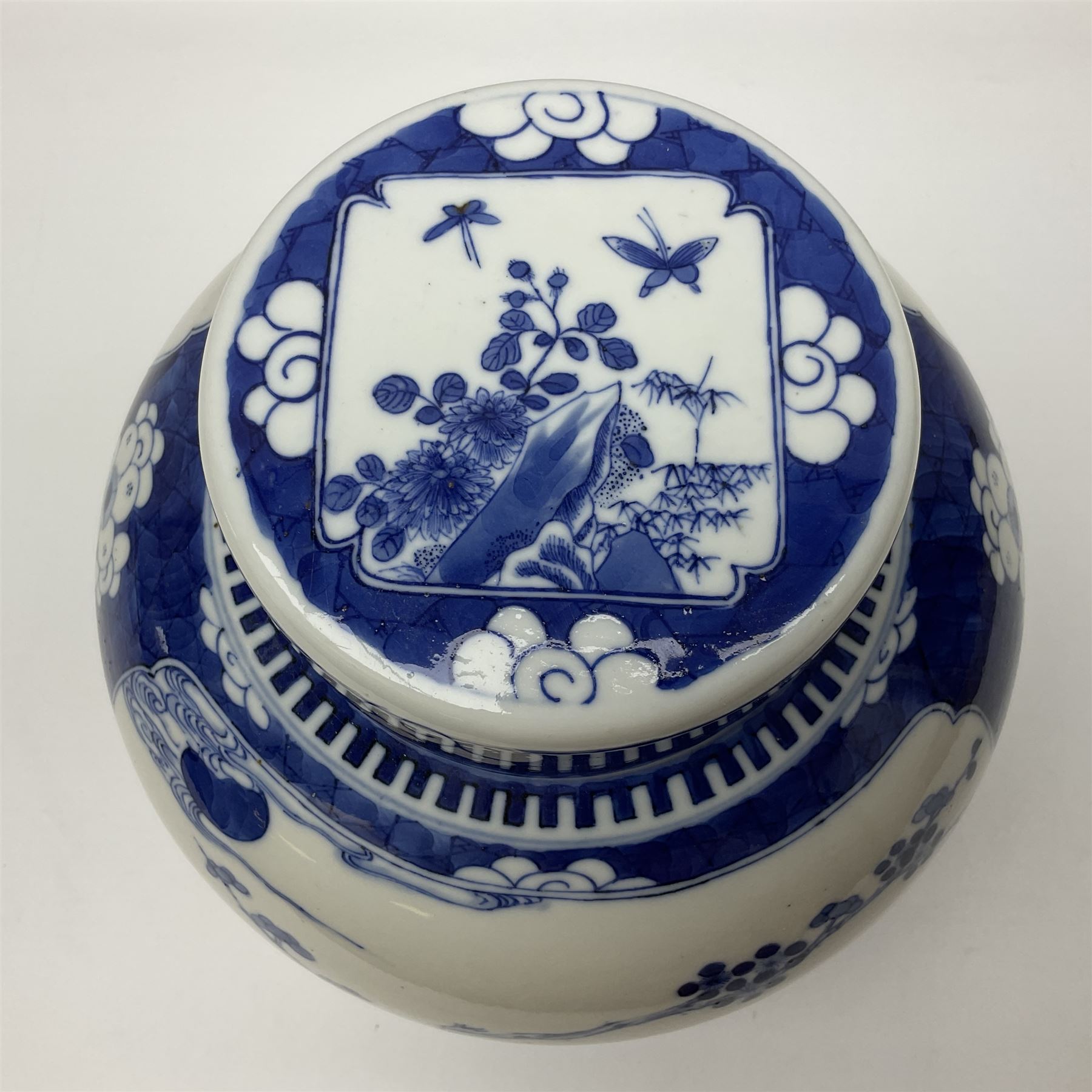 Chinese blue and white ginger jar, painted with bamboo and blossoming trees in panels against a flowerhead ground, H24cm