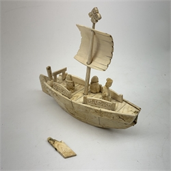 A Japanese carved ivory model of a sailing boat, surmounted by three carved figures (a/f), L22.5cm, together with a smaller sail boat with malachite hull and ivory sails and rudder, H18cm. 